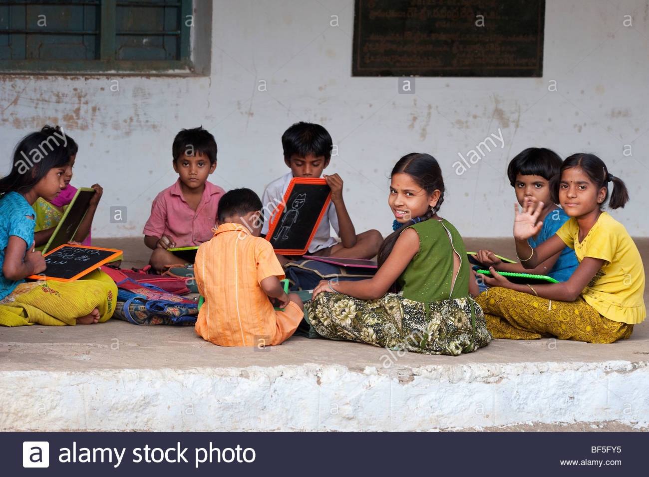 indian-school-children-sitting-outside-their-school-writing-on-chalkboards-BF5FY5_1618563270.jpg